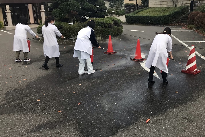 訓練用の消火器を手にして